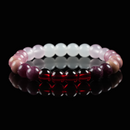 Close-up of a gemstone bracelet with vibrant red garnet, pink strawberry quartz, and soft rose quartz beads, symbolizing love, passion, and emotional wellness.
