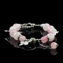 Delicate rose quartz energy bead bracelet featuring silver butterfly accents and adjustable chain, displayed elegantly on a black mirrored surface.