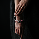 Feminine rose quartz energy bead bracelet with symbolic butterfly charms worn on hand, promoting emotional healing, love, and gentle energy alignment.