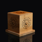 Wooden cube box with celestial sun-moon laser engraving, standing on black reflective background.