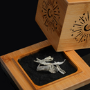 Open bamboo smudge box revealing white sage bundle inside, lid propped back, black backdrop.