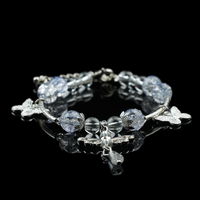 Handmade energy bead bracelet featuring clear and crackled silver-blue beads with butterfly accents and a central dragonfly pendant, symbolizing clarity and graceful transformation.