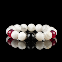 A gemstone bracelet made with snow phantom quartz, glossy black obsidian, and deep red garnet beads. The contrasting colors highlight balance between clarity, protection, and vitality, perfect for elegant everyday wear or energy alignment.
