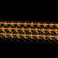 Symmetrical arrangement of three strands of high-gloss yellow crystal beads on reflective surface
