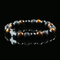 Bracelet made of tiger’s eye, lava stone, and obsidian beads with a silver cross charm, displayed on a black background to emphasize its earthy power and balance.