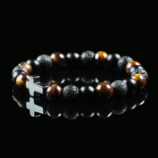 Bracelet made of tiger’s eye, lava stone, and obsidian beads with a silver cross charm, displayed on a black background to emphasize its earthy power and balance.