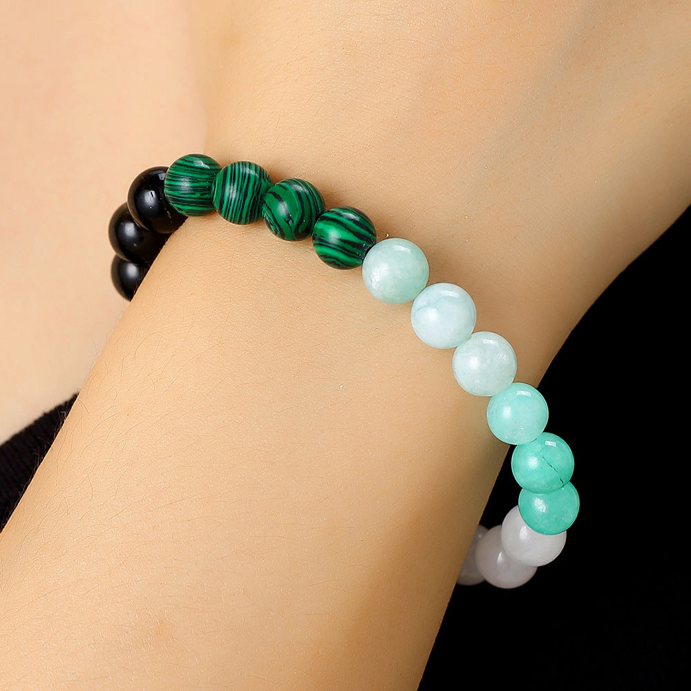 A close-up of a wrist wearing the crystal bracelet, with tiger’s eye and malachite beads visibly aligned on the outer part.