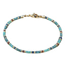 A turquoise bead anklet with gold clasp shown on a white background, highlighting its delicate structure.