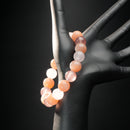 Cancer astrology bracelet worn on mannequin hand, featuring soft-toned moonstone, sunstone, and pink strawberry quartz for nurturing and protection.