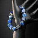 Gemini astrology bracelet worn on mannequin hand, featuring lapis lazuli cubes, round kyanite stones, and golden citrine crystal spacers.