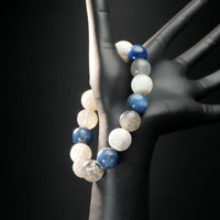 Pisces zodiac bracelet displayed on a mannequin hand, featuring blue kyanite, white moonstone, and clear quartz healing beads.