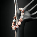 Sagittarius astrology bracelet displayed on a black mannequin hand, featuring red jasper and amazonite for adventure, vitality, and balance.