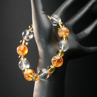 Taurus astrology bracelet worn on a mannequin hand, made with golden yellow citrine, clear quartz, and golden rutilated stones for abundance and grounding.