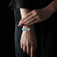 A feminine wrist adorned with a tranquil sky-blue and rose quartz bracelet, radiating softness and serenity in a minimalist fashion style.