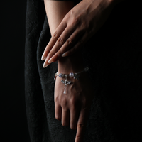 Wrist adorned with a silver-toned crystal energy bracelet featuring butterfly and dragonfly charms, reflecting intuition, freedom, and inner transformation.