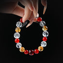 Carnelian, citrine, and clear quartz beaded bracelet held by hand on black background for vitality and abundance.