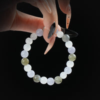 Labradorite, moonstone, and blue lace agate beaded bracelet held by hand on black background for calm, balance, and spiritual insight.